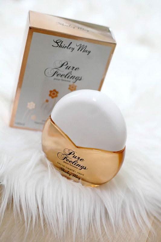 Pure Feelings Women EDT by Shirley May in 100ml bottle with pouch, featuring elegant floral design and transparent glass packaging.
