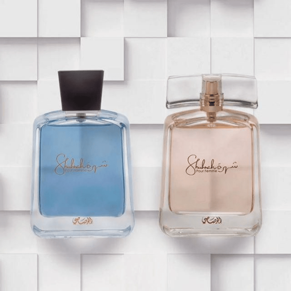 Bundle of Rasasi Shuhrah Men & Women EDP 90ml bottles, showcasing elegant perfume packaging with floral and woody fragrance elements