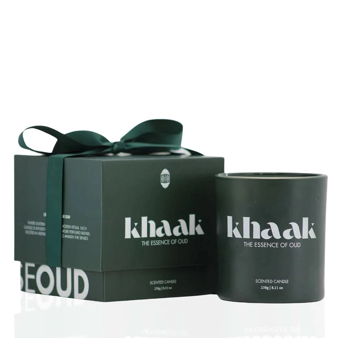 Intense Oud Khaak scented candle with driftwood, lily of the valley, Istanbul rose, and moss notes in a white ceramic holder.