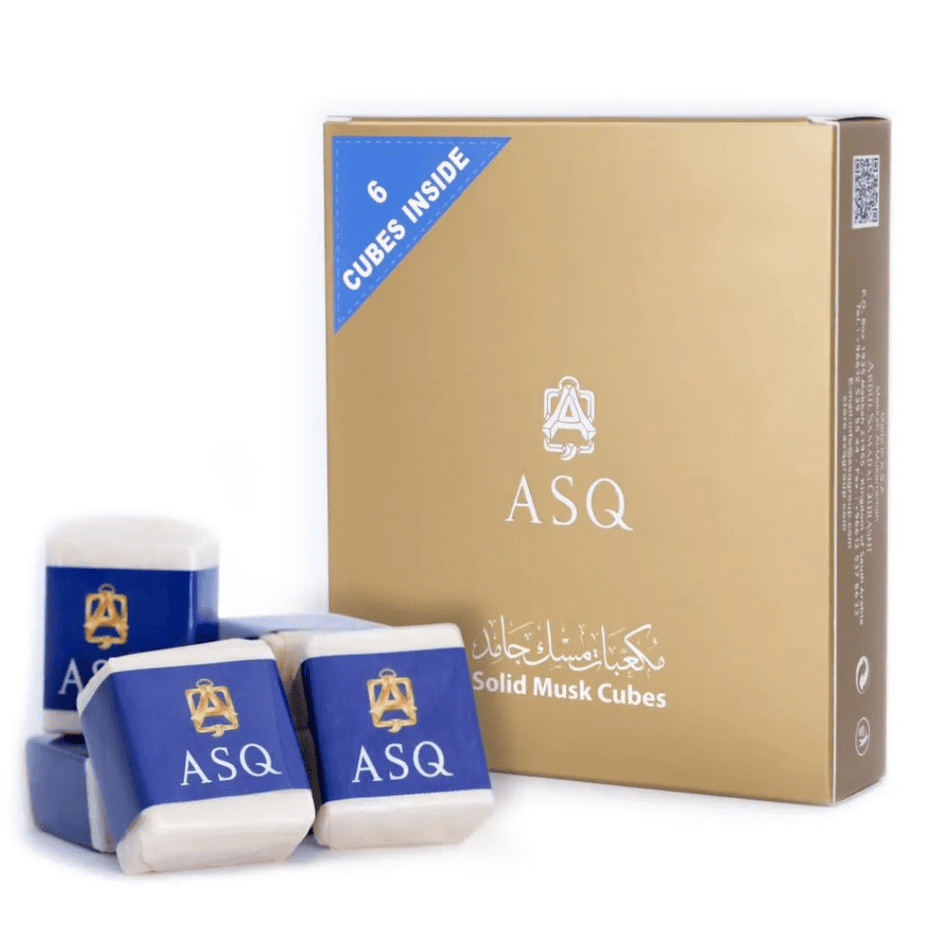 Six solid musk cubes by Abdul Samad Al Qurashi, displayed in a clear container, showcasing the aromatic musk fragrance.