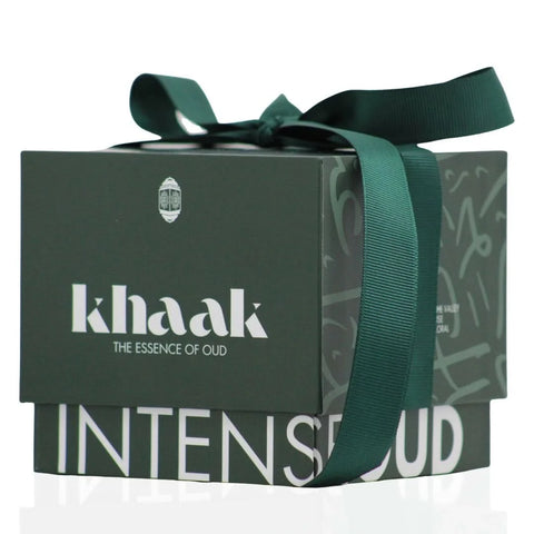 Intense Oud Khaak scented candle with driftwood, lily of the valley, and rose notes in a elegant glass holder.