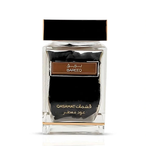 Rasasi Qasamat Bareeq Oudh Moattar Bakhoor 50g in a decorative container with fragrant wood chips for traditional incense.