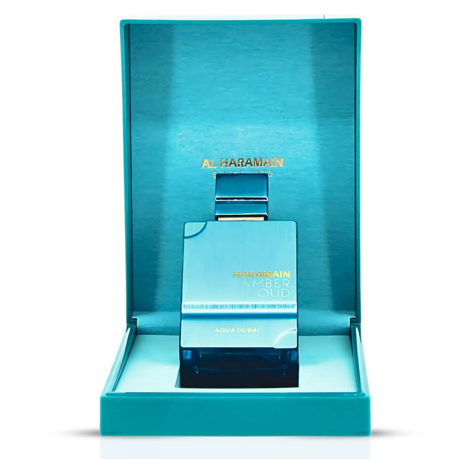 Amber Oud Aqua Dubai Extrait de Parfum spray by Al Haramain, featuring a sleek glass bottle with a golden cap.