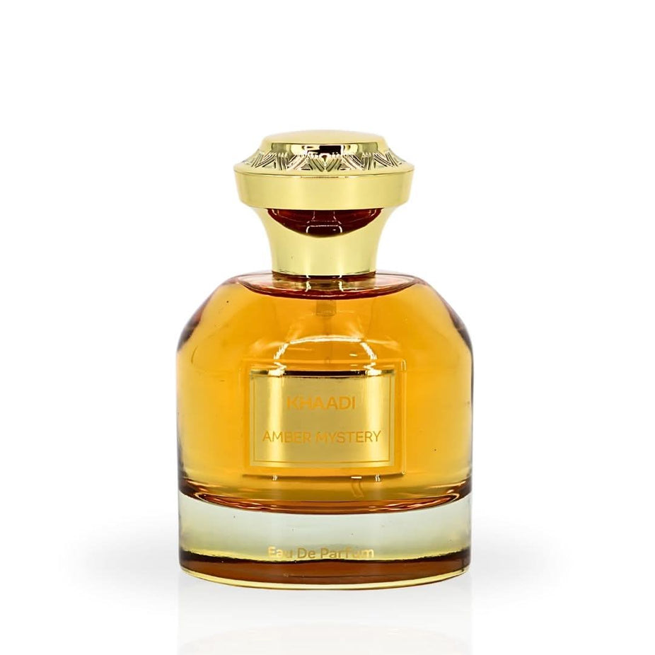 Khaadi Amber Mystery Eau de Parfum spray with velvet pouch, 100ml bottle, elegant packaging and amber-colored perfume inside.