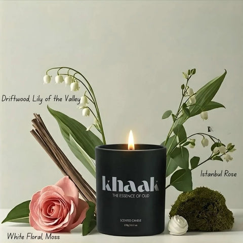 Intense Oud Khaak scented candle with driftwood, lily of the valley, Istanbul rose, white florals, moss, in a glass holder.