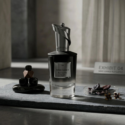Mind Games Ruy Lopez Extrait de Parfum 100ml EDP bottle with elegant black and gold design on a reflective surface