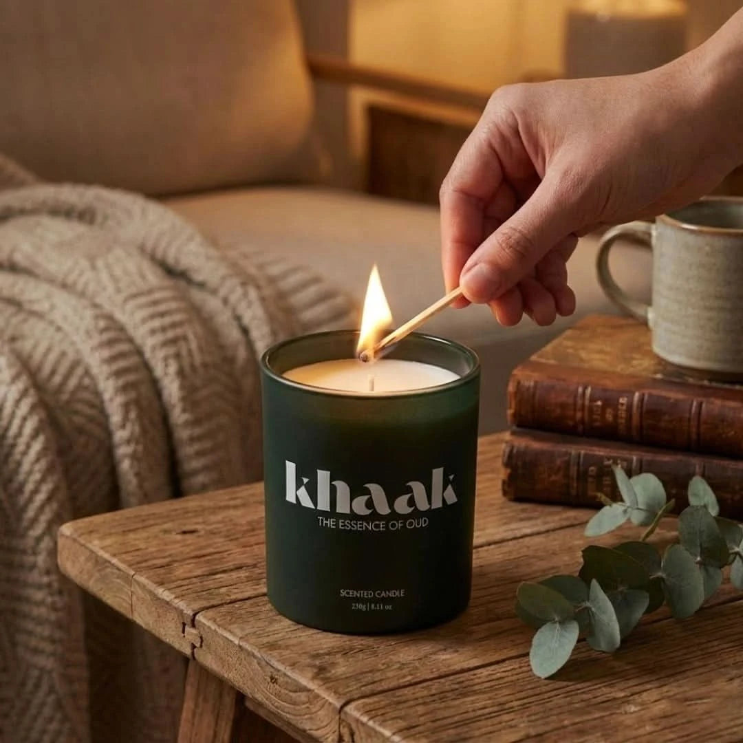 Intense Oud Khaak scented candle with driftwood, lily of the valley, Istanbul rose, white florals, and moss in a glass jar.