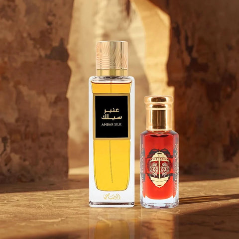 Rasasi Ambar Silk Eau de Parfum spray and Gold Saffron perfume oil duo in elegant bottles, showcasing warm spice and refined elegance.