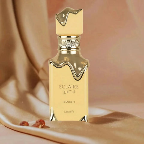 Lattafa Eclaire Banoffi Eau de Parfum Spray 100ml with velvet pouch, featuring elegant bottle design and luxurious fragrance presentation.