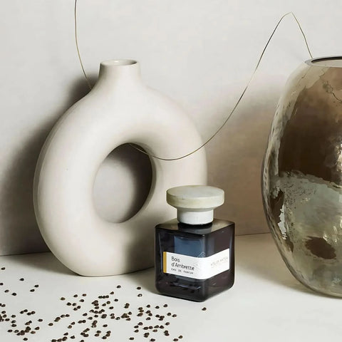 Atelier Materi Bois d'Ambrette Eau de Parfum spray bottle, 100ml, with elegant packaging and amber-colored fragrance liquid.