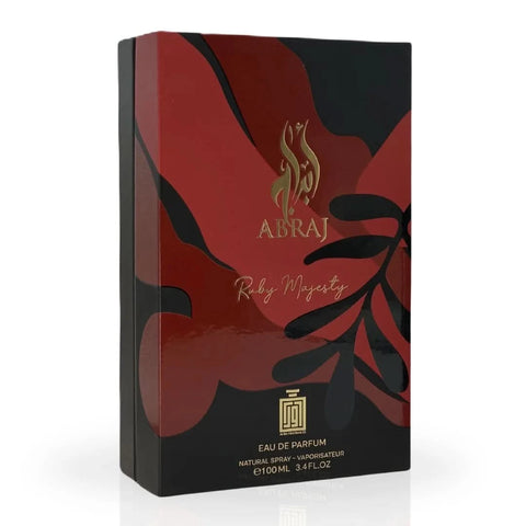 Aura Fragrances Abraj Ruby Majesty Eau De Parfum spray 100ml bottle on a reflective surface with elegant packaging.