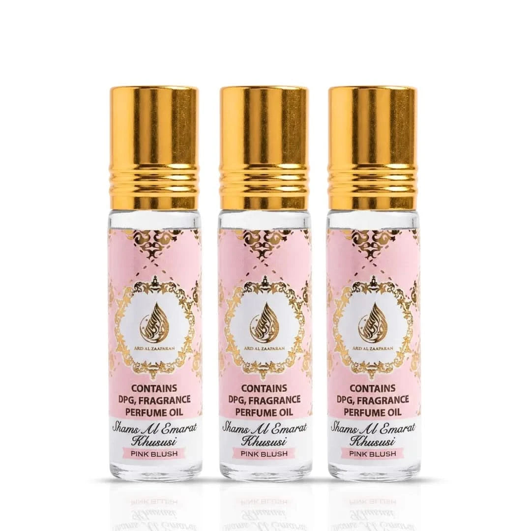 Three pink Blush Shams Al Emarat Khususi roll-on perfume oils by Ard Al Zaafaran in 10ml bottles, with pink and gold packaging.