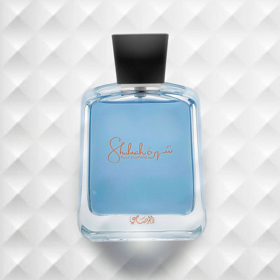 Rasasi Shuhrah Pour Homme EDP 90ml in elegant velvet pouch, featuring the perfume bottle with its sleek design and cap.