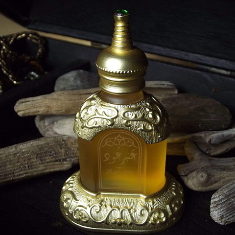Amber Ood perfume oil by Rasasi in a 14 ML bottle, displayed with a velvet pouch, showcasing the concentrated perfume oil packaging.